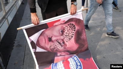 Demonstrators hold banners during a protest against France, in Istanbul,Turkey, Oct. 27, 2020.