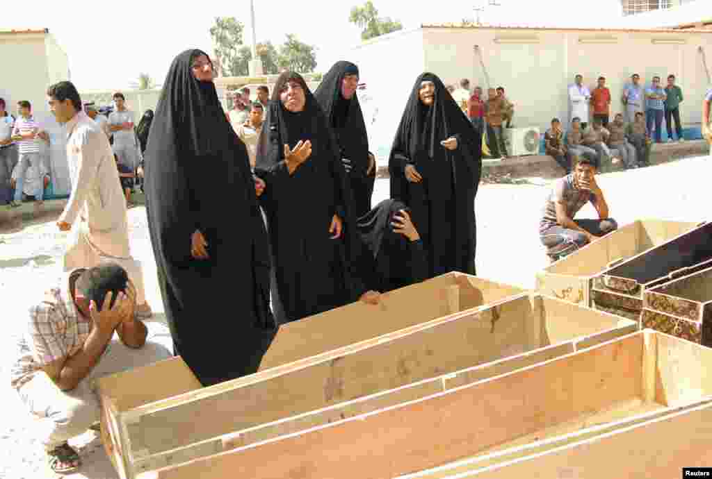 Women react near empty coffins as they wait to claim the bodies of their relatives, who were killed by gunmen, at a hospital morgue outside of Baghdad, Sept. 4, 2013. 