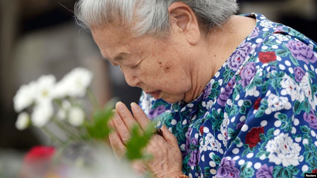 Seorang perempuan Jepang mengenang korban bom atom dengan berdoa di Taman Perdamaian di Hiroshima, Rabu (6/8). 