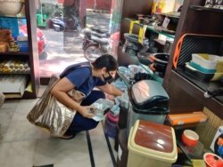 A customer turns up to buy baking tins -- in Delhi, like much of the world, cooking and baking has been a therapy for people confined indoors. (Anjana Pasricha/VOA)