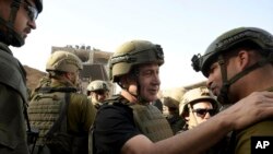 FILE —Israel's Prime Minister Benjamin Netanyahu, center, greets soldiers as he visits the Gaza Strip, where he received security briefings with commanders and soldiers and visited one of the tunnels that has been revealed, on Sunday, November 26, 2023.