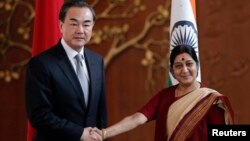 Menlu China Wang Yi (kiri) bertemu Menlu India Sushma Swaraj di New Delhi hari Minggu (8/6). 