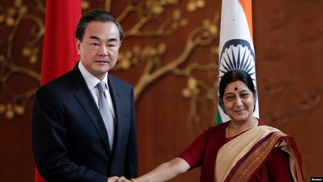 Menteri Luar Negeri China Wang Yi (kiri) berjabat tangan dengan Menteri Luar Negeri India Sushma Swaraj sebum pertemuan di New Delhi 8 Juni 2014.