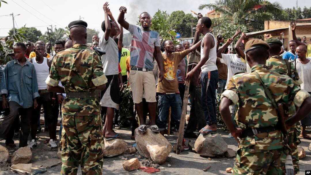 FILE - Oposition demonstrators confront army soldiers in the Mutarakura district, as security forces try to prevent people from moving out of their neighborhoods, in the capital Bujumbura, Burundi.