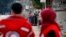 FILE - Members of the Syrian Red Cross stand near aid vehicles in the besieged town of Madaya about 15 miles (24 kilometers) northwest of Damascus, Syria, Jan. 11, 2016. Red Cross trucks were refused entry Thursday in the Syrian town of Daraya.
