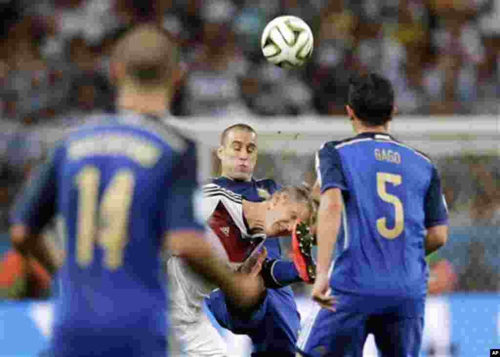 Germany's Bastian Schweinsteiger, bottom center, challenges Argentina's Rodrigo Palacio during the World Cup final soccer match between Germany and Argentina at the Maracana Stadium in Rio de Janeiro, Brazil, Sunday, July 13, 2014. (AP Photo/Matthias Schr