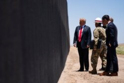 FILE - U.S. Border Patrol chief Rodney Scott gives President Donald Trump a tour of a section of the border wall, June 23, 2020, in San Luis, Ariz.
