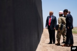 FILE - U.S. Border Patrol chief Rodney Scott gives President Donald Trump a tour of a section of the border wall, June 23, 2020, in San Luis, Ariz.