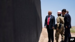 FILE - U.S. Border Patrol chief Rodney Scott gives President Donald Trump a tour of a section of the border wall, June 23, 2020, in San Luis, Ariz.