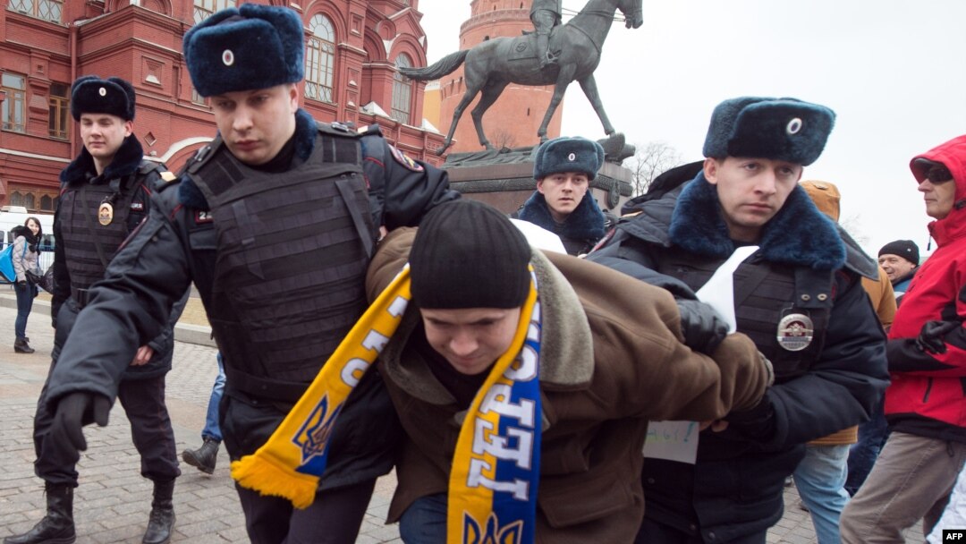 Police officers detain a protester in central Manezhnaya Square in Moscow, on March 2, 2014, during an unsanctioned rally against the Russia's military actions in Crimea. 