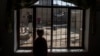 A boy stands at window as an official from the World Food Program interviews his family, in Kabul, Afghanistan, Nov. 18, 2021. 