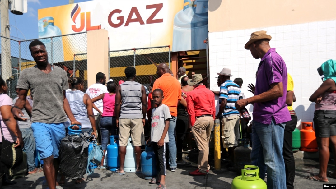 Moun ki t ap tann pou yo achte gaz nan yon makèt nan Pòtoprens, Ayiti, an jounen samdi 16 fevriye 2019 la. 