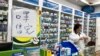 Pharmacist Liu Zhuzhen stands near a sign reading "face masks are sold out" at her pharmacy in Shanghai, China, Jan. 21, 2020.