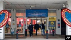 People leave the Charing Cross hospital in London, Friday, Jan. 8, 2021. Britain’s National Health Service will from next week employ a little-used field hospital specially built at a huge exhibition center in east London in the early days of the…