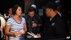Yanira Maldonado, 42, left, accompanied by her husband, Gary, center, speaks to an official after being released from prison near Nogales, Mexico, May 30, 2013.