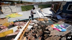 Benjamin Luna helps recover items from the children's wing of the First Pentecostal Church that was destroyed by Hurricane Laura, Aug. 27, 2020, in Orange, Texas.