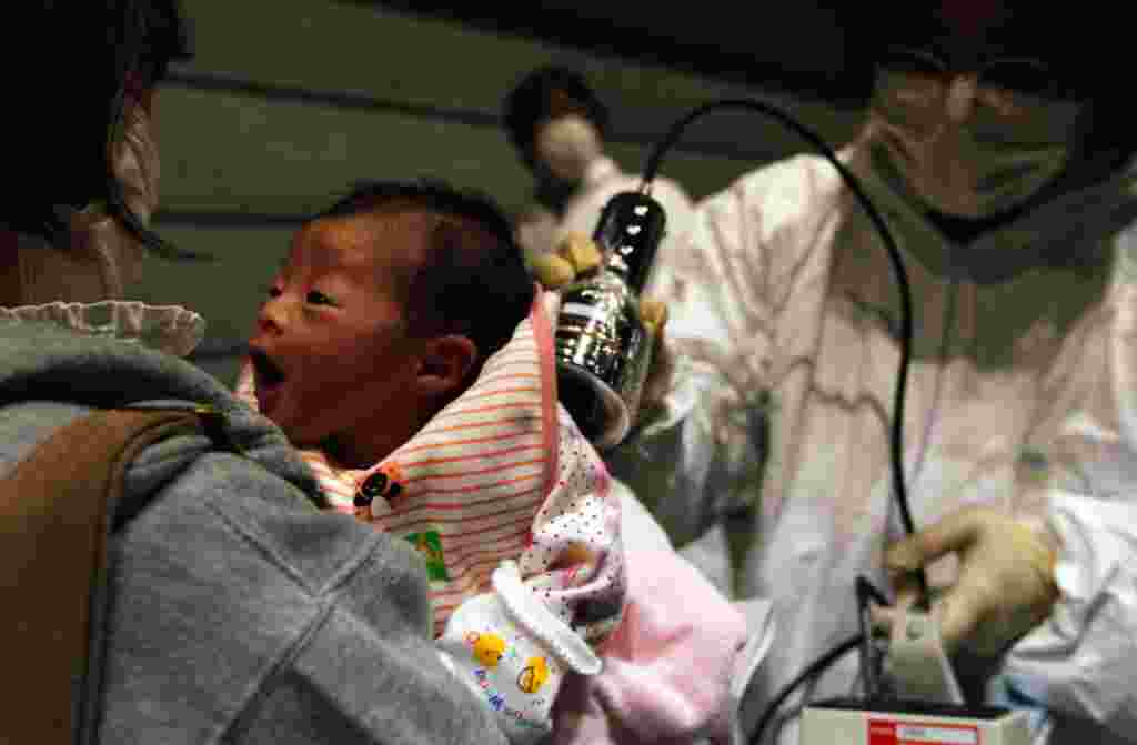 Nagashima Rio, who was born four days after the 2011 Fukushima earthquake and tsunami, is tested for possible nuclear radiation at a local evacuation center. (REUTERS/Kim Kyung-Hoon)