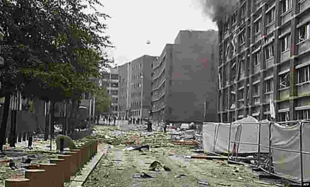 In this video image taken from television, smoke is seen billowing from a damaged building as debris is strewn across the street after an explosion in Oslo, Norway, Friday, July 22, 2011