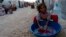 A Kurdish refugee girl from the Syrian town of Kobani washes in front of their family tent in a camp near the Syria-Turkey border in the southeastern town of Suruc, Turkey, Oct. 10, 2014.
