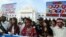 Clad in traditional attire, activists march during a rally to end the fighting in northern Burma, in downtown Rangoon, Tuesday, Jan. 1, 2013.
