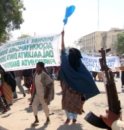 Protesters carry banners which reads" Down with those who carried the killings" in Mogadishu, Somalia, Monday, Dec. 7, 2009.