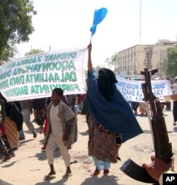 Protesters carry banners which reads" Down with those who carried the killings" in Mogadishu, Somalia, Monday, Dec. 7, 2009.