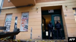 FILE —Policemen stand on November 23, 2023 in front of a house in Berlin's Friedrichshain district, as a raid was under way against Hamas and another Palestinian organisation which are banned in the country.