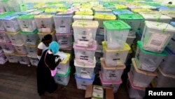 Polling clerks record information on a pile of ballot boxes containing cast ballot papers at the Chandaria tallying center in Kenya's coastal city of Mombasa, March 6, 2013. 