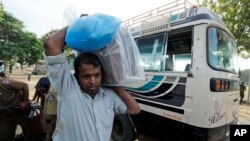 Seorang petugas pemilu Sri Lanka mengangkat kotak suara yang masih tersegel dari sebuah bus di pusat penghitungan suara di Jaffna, Sri Lanka (21/9).