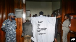 FILE - Ugandan MP John Musila wears clothes with an anti-LGBTQ message as he enters the Parliament to vote on a harsh new anti-gay bill, on Tuesday, March 21, 2023.