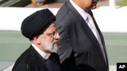 El presidente de Irán, Ebrahim Raisi, a la izquierda, camina con el presidente de Venezuela, Nicolás Maduro, cuando llega al palacio presidencial de Miraflores en Caracas, Venezuela, el lunes 12 de junio de 2023. (Foto AP/Ariana Cubillos)