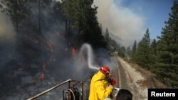 Petugas pemadam kebakaran Union Pacific Fire Train berupaya memadamkan Dixie Fire di Plumas National Forest, California, AS, 17 Juli 2021. (REUTERS/David Swanson)
