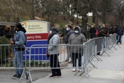 People queue to enter a tent erected to test for the coronavirus disease (COVID-19) at the Brooklyn Hospital Center in Brooklyn, New York City, March 19, 2020.