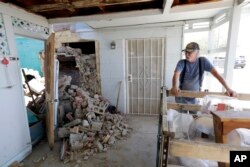 Eugene Johnson looks at the chimney collapsed by an earthquake the day before at his home in Trona, Calif., July 6, 2019. Crews in Southern California were assessing damage to buildings, roads, water and gas lines, and other infrastructure.