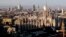 FILE - The pinnacles of the Duomo cathedral are lit by the afternoon sun and backdropped by the new Business Center, in Milan, northern Italy.