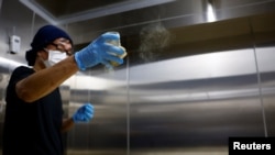 Yoshimi Terasawa, chief brewer at Tokyo Port Brewing, sprinkles the spores of koji fungus over cooled steamed rice as a part of brewing sake, a traditional rice wine, at the brewery in Tokyo, Japan July 9, 2024. (REUTERS/Kim Kyung-Hoon)