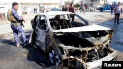 Iraqi security forces inspect the site of a bomb attack, after a parked motorcycle blew up, in Kirkuk, Oct. 13, 2014. 