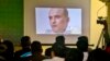 FILE - Journalists look a image of Indian naval officer Kulbhushan Sudhir Jadhav during a news conference by Pakistan's army spokesman and information minister, in Islamabad, March 29, 2016.