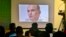 FILE - Journalists look a image of Indian naval officer Kulbhushan Jadhav, who was arrested in March 2016, during a press conference by Pakistan's army spokesman and the Information Minister, in Islamabad, Pakistan, March 29, 2016.