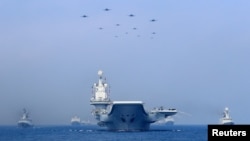 FILE PHOTO - Warships and fighter jets of the Chinese People's Liberation Army (PLA) Navy take part in a military display in the South China Sea April 12, 2018.