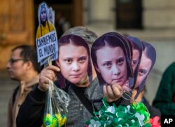 A man sells Greta Thunberg masks during a climate protest rally in Santiago, Chile, Sept. 27, 2019.