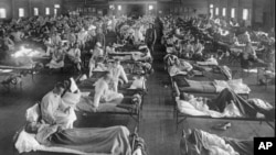 FILE - Influenza victims crowd into an emergency hospital near Fort Riley, Kansas in 1918, when the Spanish flu pandemic killed at least 20 million people worldwide.