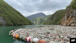 In this photo taken on Tuesday, April 23, 2019, plastic bottles and other garbage float in the river Drina near Visegrad, eastern Bosnia-Herzegovina. (AP Photo/Eldar Emric)