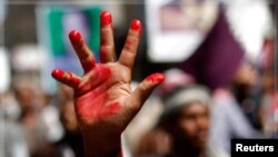 An anti-government protester raises a hand painted in red to symbolize bloodshed during a demonstration to demand the ouster of Yemen's President Ali Abdullah Saleh in the southern city of Taiz November 1, 2011.
