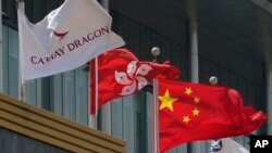 香港國泰航空公司總部大樓外公司旗幟在香港特區旗幟和中國國旗旁飄揚。 （2020年10月21日）