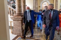 Sen. Bernie Sanders, I-Vt., left, and Senate Majority Leader Chuck Schumer of N.Y., right, walk out of a budget resolution meeting at the Capitol in Washington, Aug. 9, 2021.