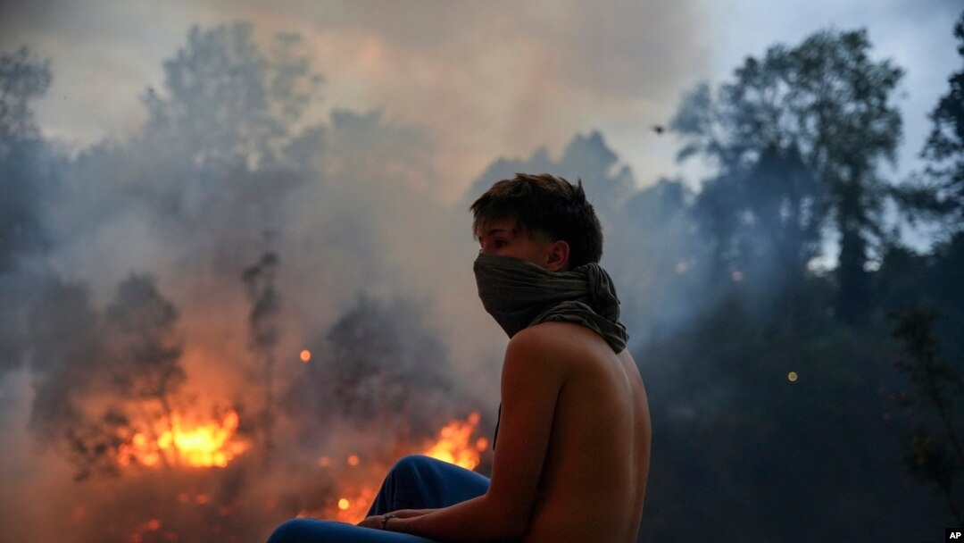 Un residente mira el fuego ante un incendio en la zona boscosa del barrio del Guápulo en Quito, Ecuador, el martes 24 de septiembre de 2024.