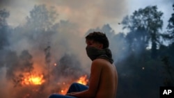 Un residente mira el fuego ante un incendio en la zona boscosa del barrio del Guápulo en Quito, Ecuador, el martes 24 de septiembre de 2024.