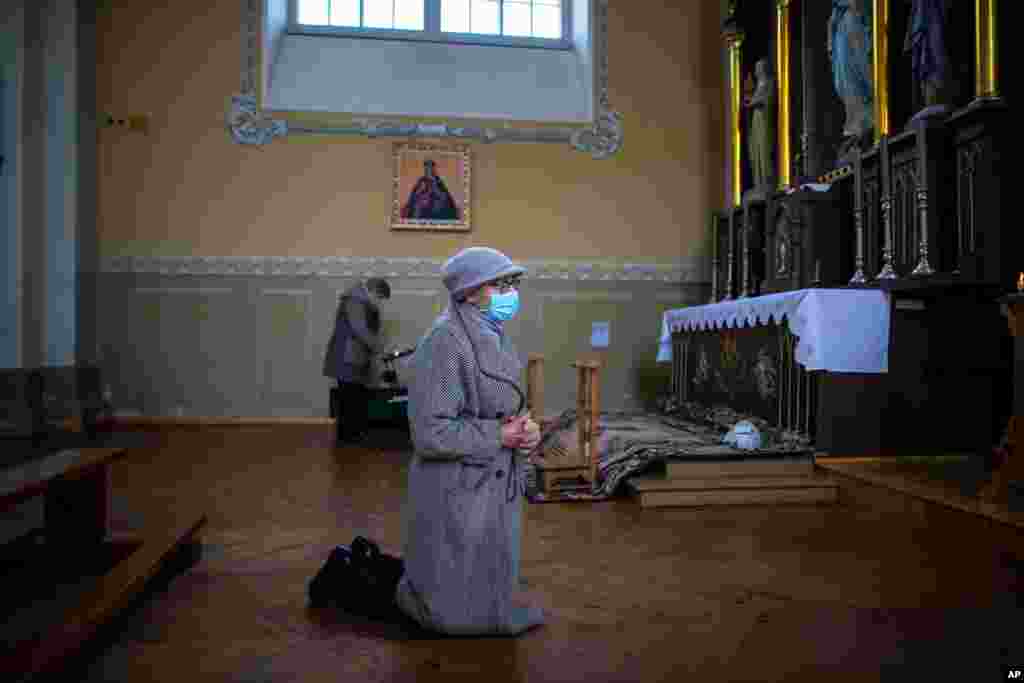A woman prays during the Sunday Mass at the St. Trinity Church in a small town Tverecius, some 135km (83.1 miles) northeast of the capital Vilnius, Lithuania, during the outbreak of COVID-19.