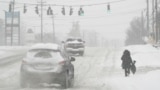 In this photo, heavy snow falls as a person walks along U.S. Route 42 in Florence, Ky., Monday, Jan. 6, 2025. (AP Photo/Carolyn Kaster, File)